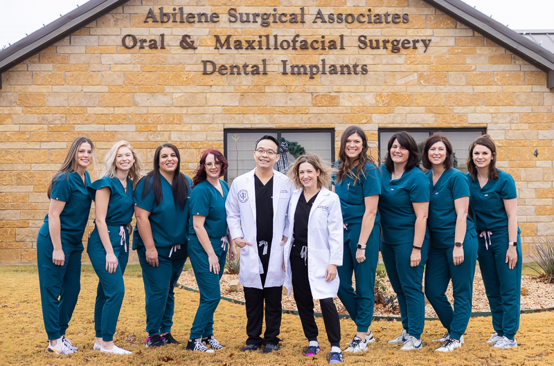 Abilene Surgical Associates team standing in front of the building, smiling and posing for a group photo