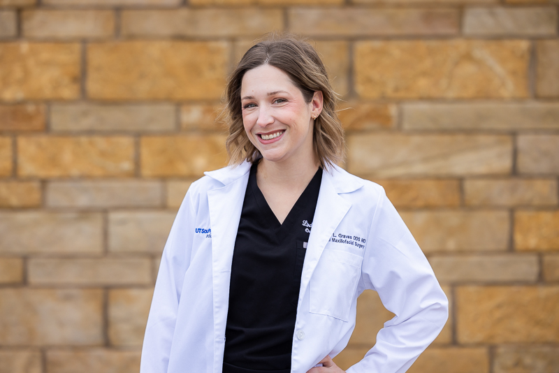 Image of Dr. Lindsey Graves, DDS, MD, standing in front of Abilene Surgical Associates building