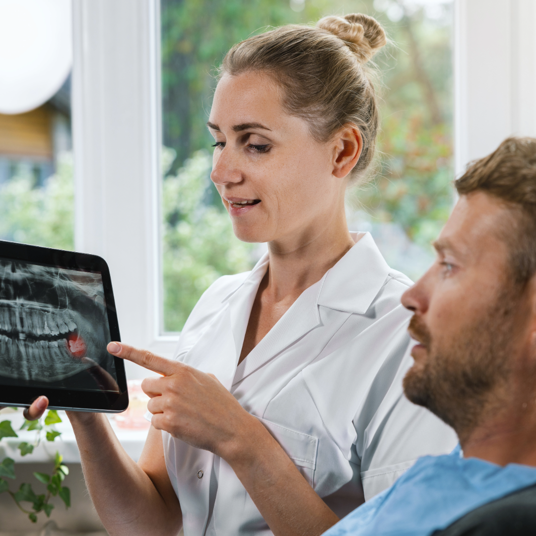 Female dental assistant showing impacted tooth x-ray